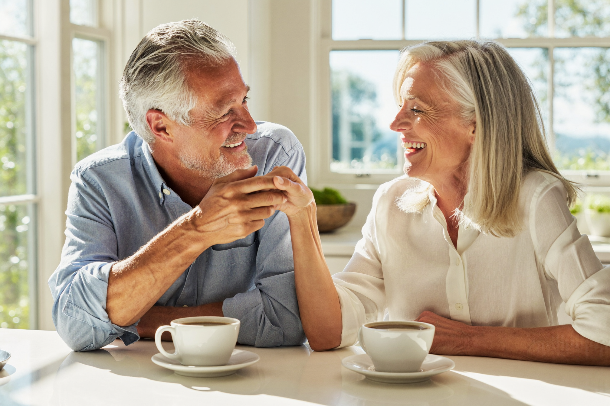 A rested couple in their 60s enjoying morning coffee